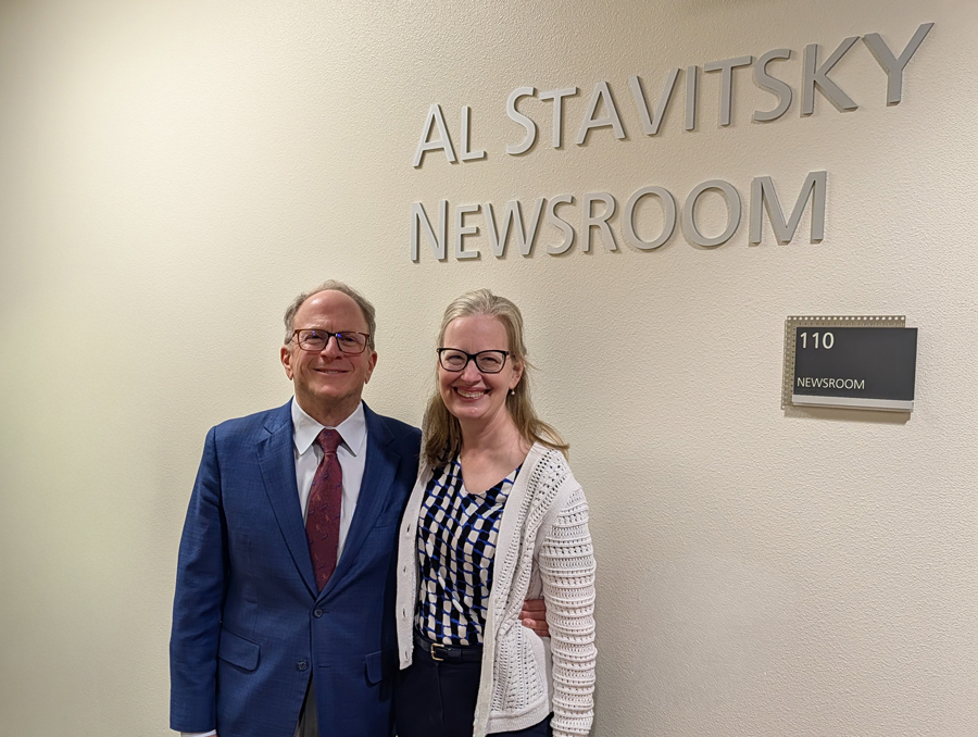 Al Stavitsky and his wife, Kristen, stand outside the newsroom under a sign that reads "Al Stavitsky Newsroom."