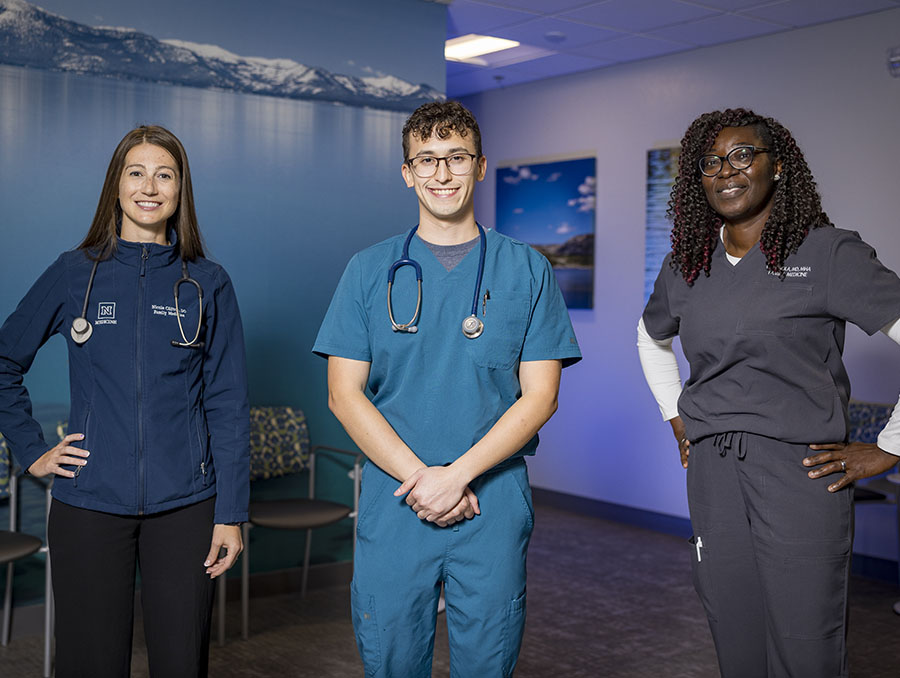 Three resident physicians standing in a clinical waiting room.