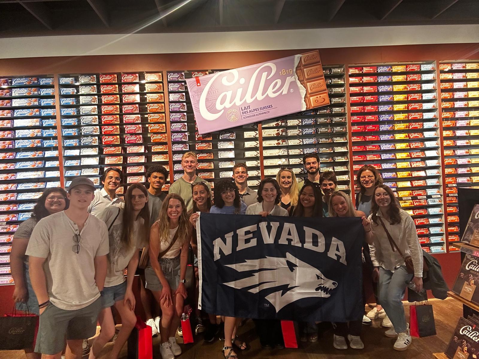 Students hold Nevada flag while at a company tour.