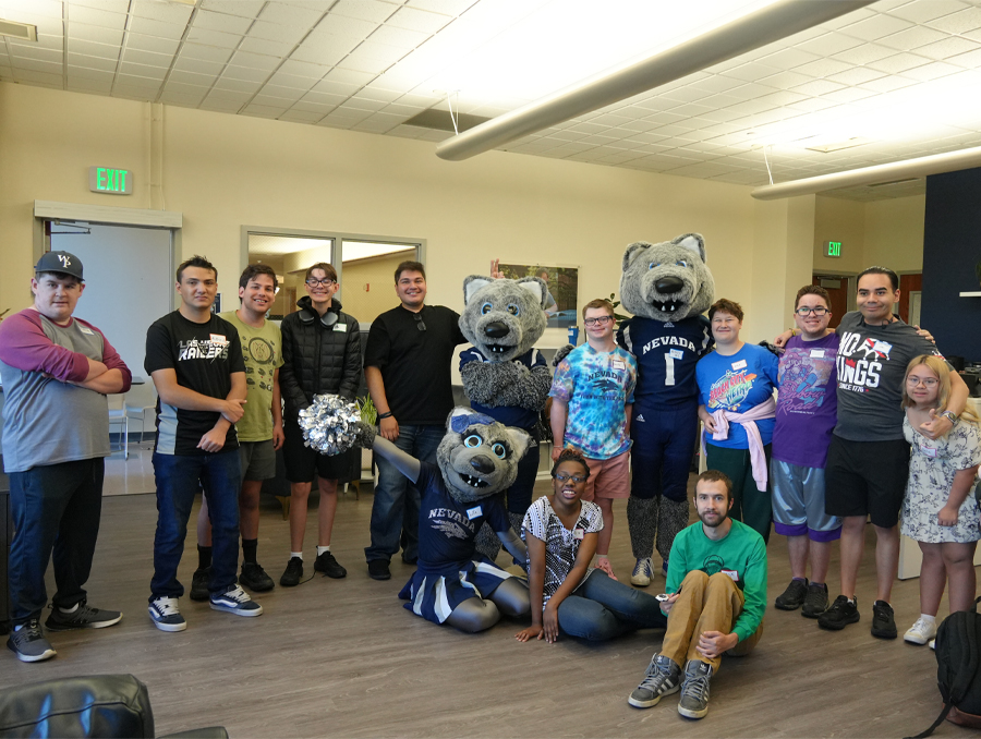 Path to Independence students stand with wolf mascots in a classroom.