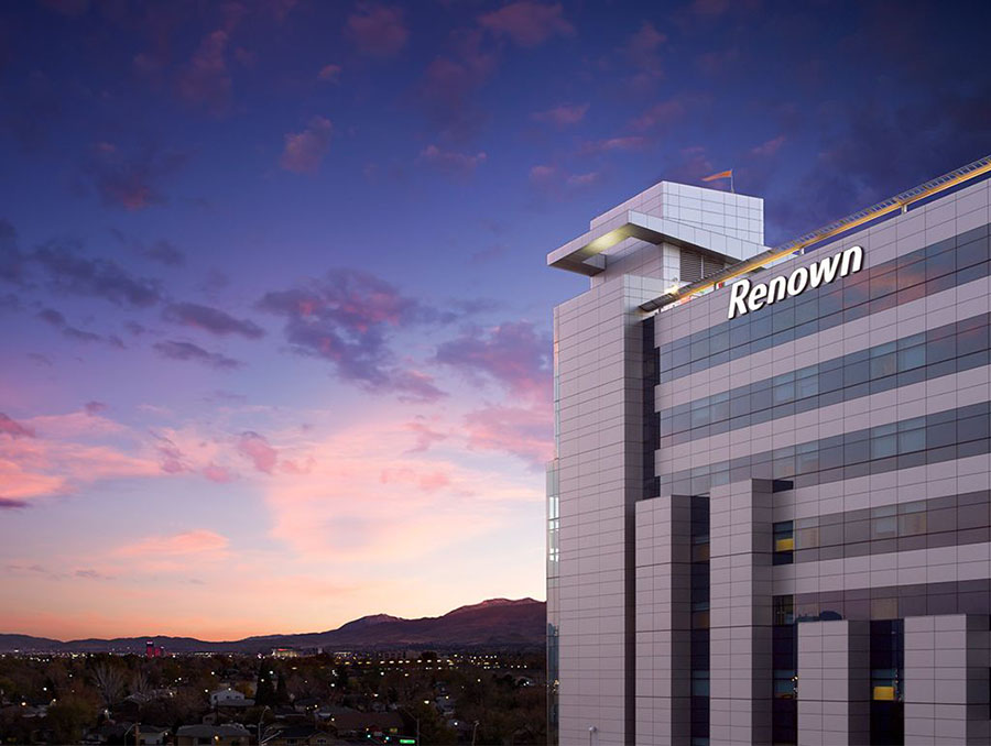 Renown Regional Medical Center tower in downtown Reno with a sunset background.