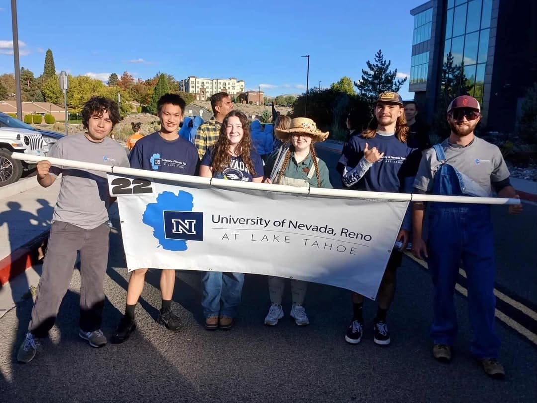 Students in the Semester at Lake Tahoe program carry banner on the main campus that reads "University of Nevada, Reno at Lake Tahoe."