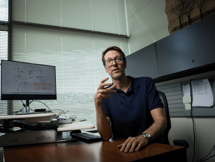 Euan Allan, Ph.D. sitting in his office, talking to the camera.