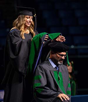 David Tingle getting hooded during the medical school graduation commencement.