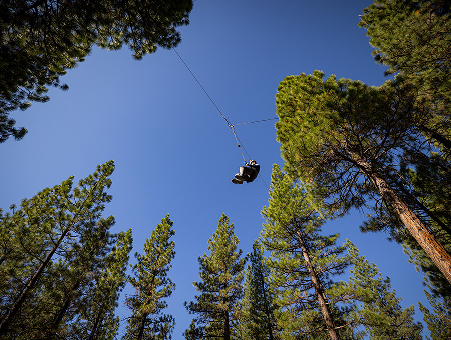 Julie Hardt suspended in the air by rope at Flying Squirrel challenge course.