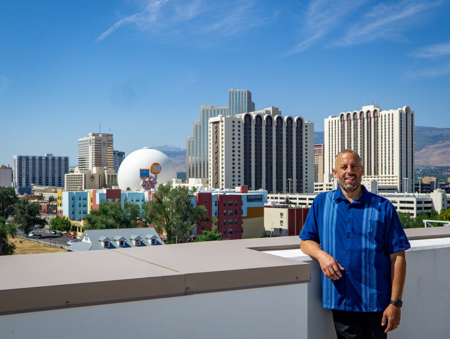 Jody leaning against a wall with the Reno skyline behind him.