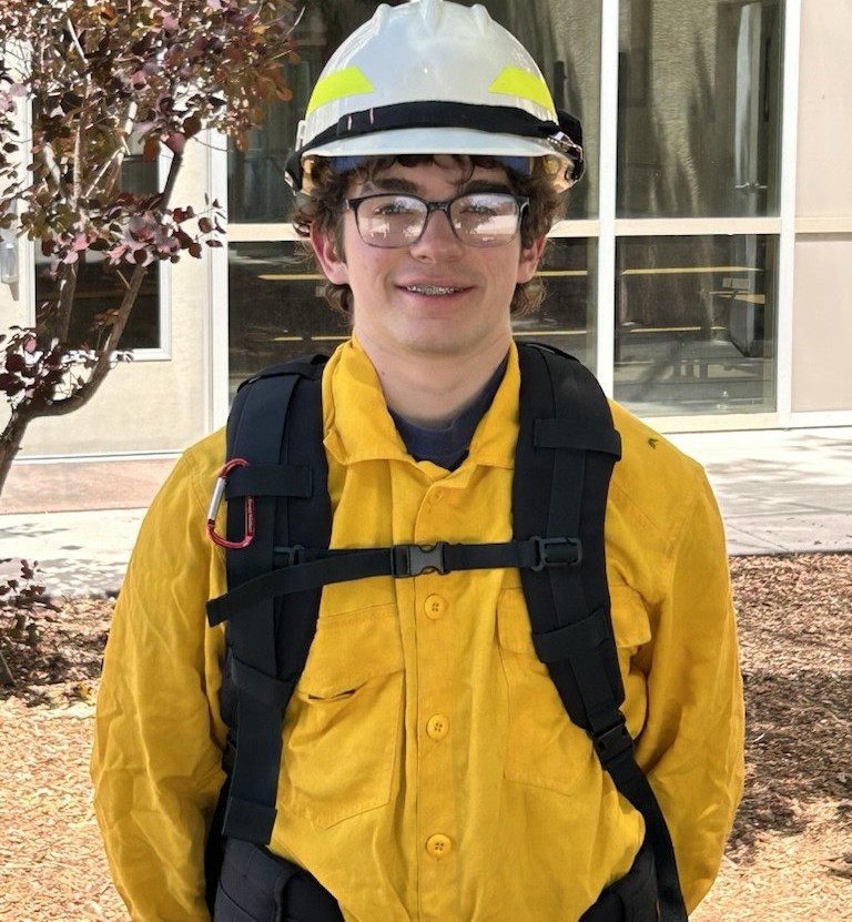 Kai Hueber poses for a photo in firefighting gear.