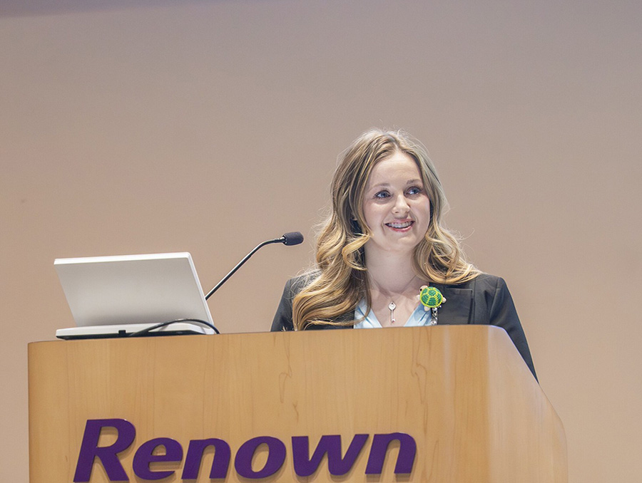 Natalie Osborn, M.D., speaking into a microphone at a podium.