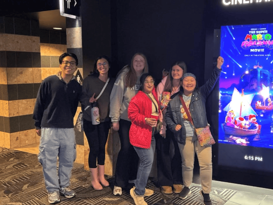 A group of young people posing in a movie theater.