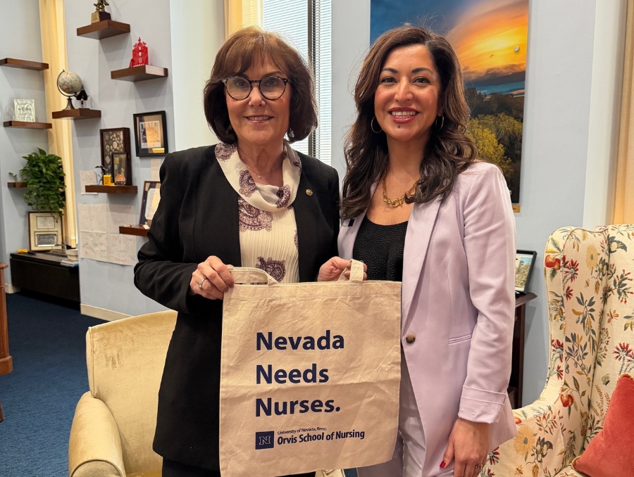 Vania Carter-Strauss in Senator Jacky Rosen's office posing for a photo while holding an Orvis School of Nursing branded bag that reads "Nevada Needs Nurses."