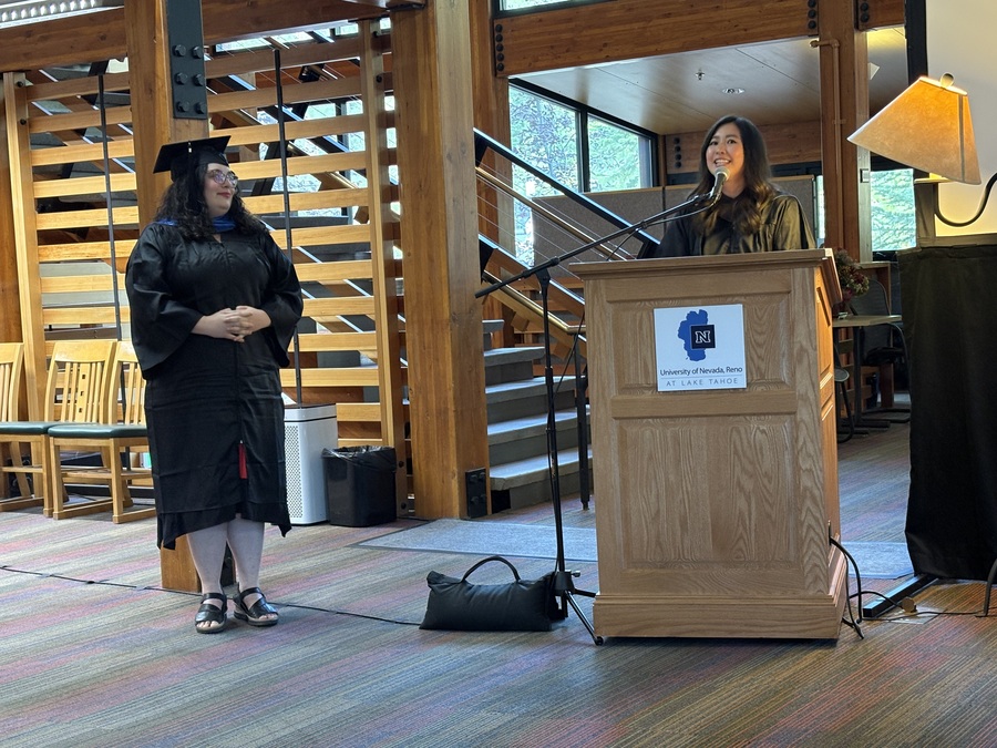 Abby stands at her graduation in cap and gown.