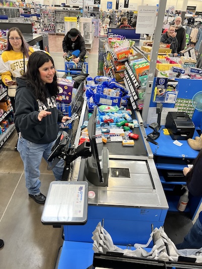 Someone at a checkout stand with lots of supplies on the conveyor belt.