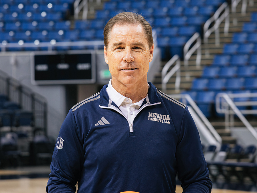 Image of Kelly Sopak wearing a navy blue quarter-zip with the adidas logo on one side and NEVADA BASKETBALL text on the other