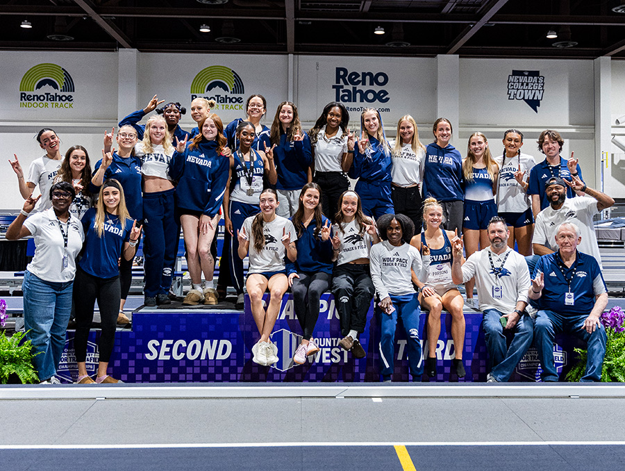 Track and field team posing on podium.