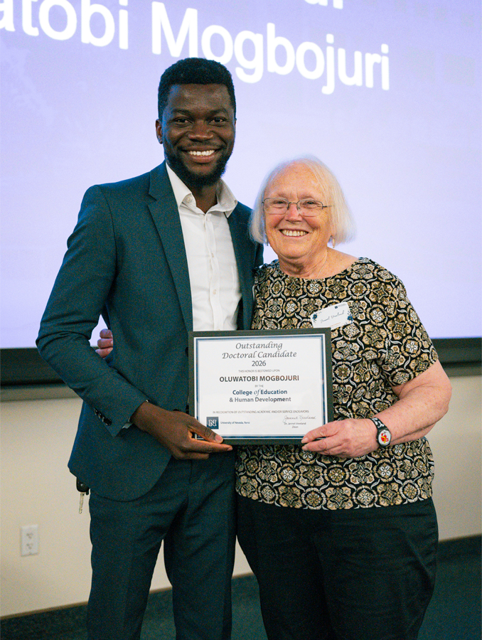 Oluwatobi Mogbojuri stands next to Jannet Vreeland, Ph.D., holding his award.