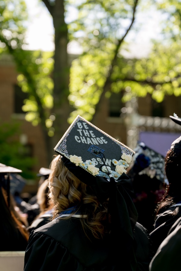 A graduate's cap that reads "Be the change."
