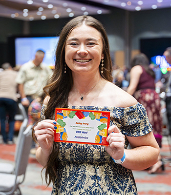 Bailey Ivory holds up a sign that shows she matched into the Pediatrics Residency Program at UNR Med.