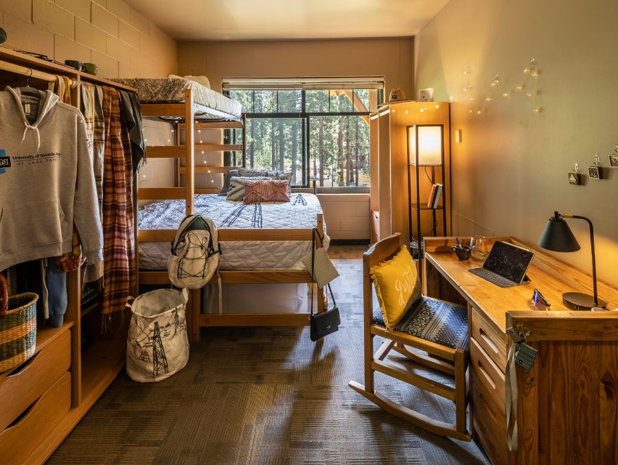 Dorm room interior with bed, desk, and drawers in Lake Tahoe.