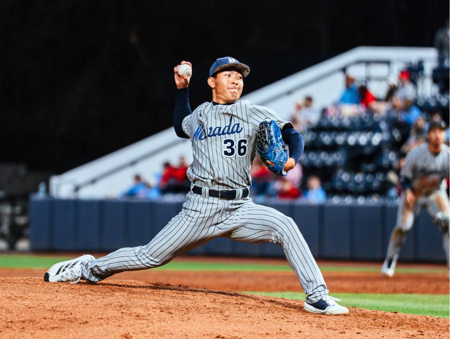 Nevada Baseball's Mahiro Tomita pitching with a crowd in the background.