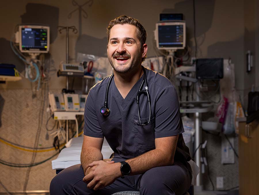 Cameron Shonnard wearing scrubs and a stethoscope in a clinical room.