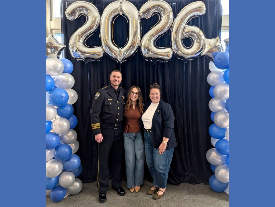 Deputy Chief Reynolds, Emma Lawson, and Madison Eifert pose under balloons that read "2026."