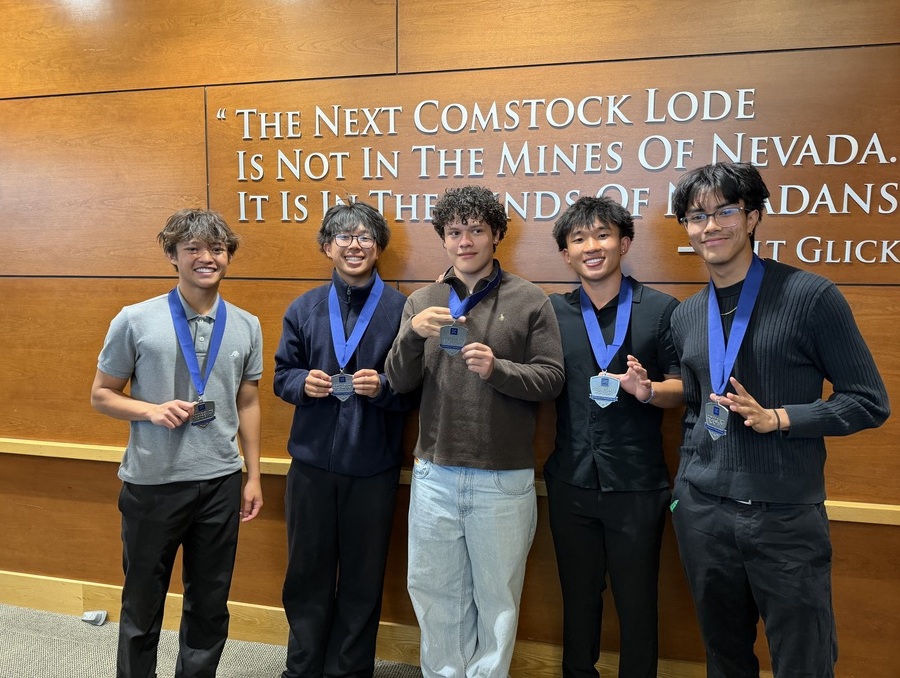 Five students hold medals at the ceremony. 