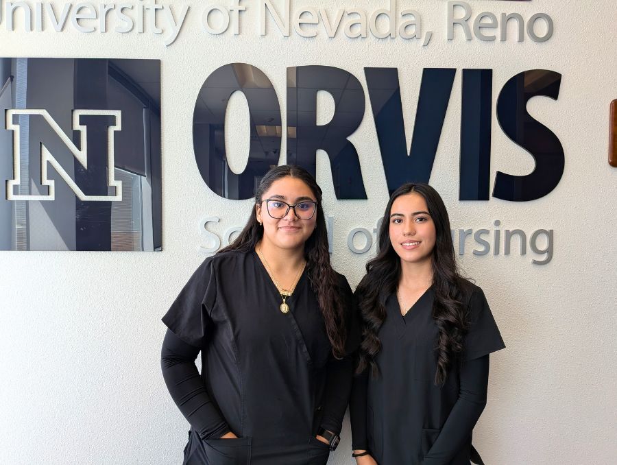 Fatima and Jaqueline standing in front of an Orvis School of Nursing sign