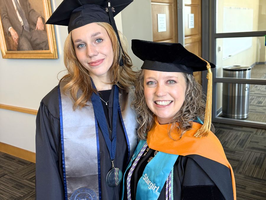 Riley Wagner with Stacy Demitropoulos dressed in graduation attire at Convocation.