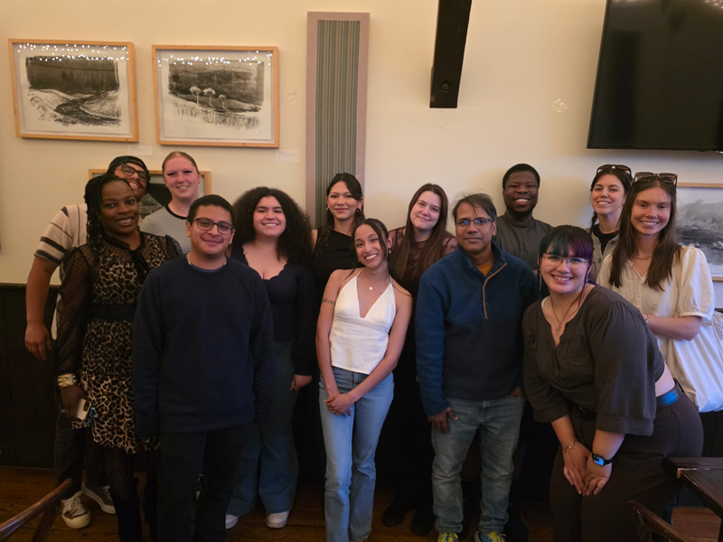 A group of people smile for a photo at a social gathering.