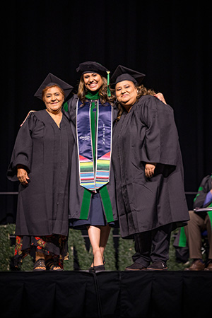 Lourdes Valdez hugging her family members after being hooded on stage.