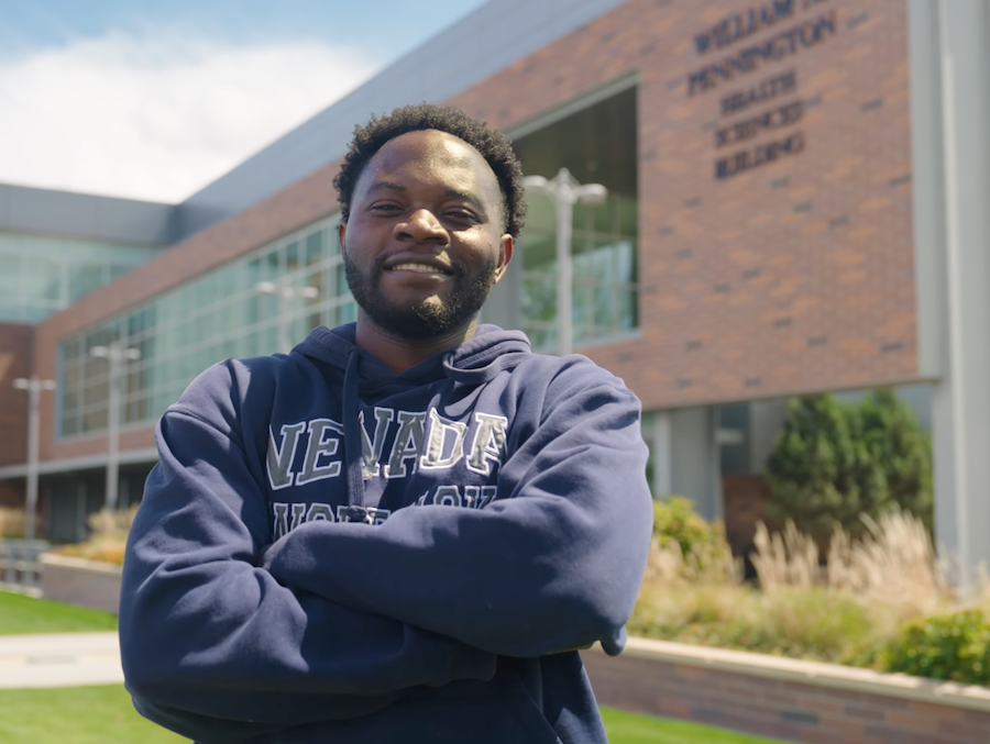 Luka in a Nevada sweatshirt, smiling outside on campus.