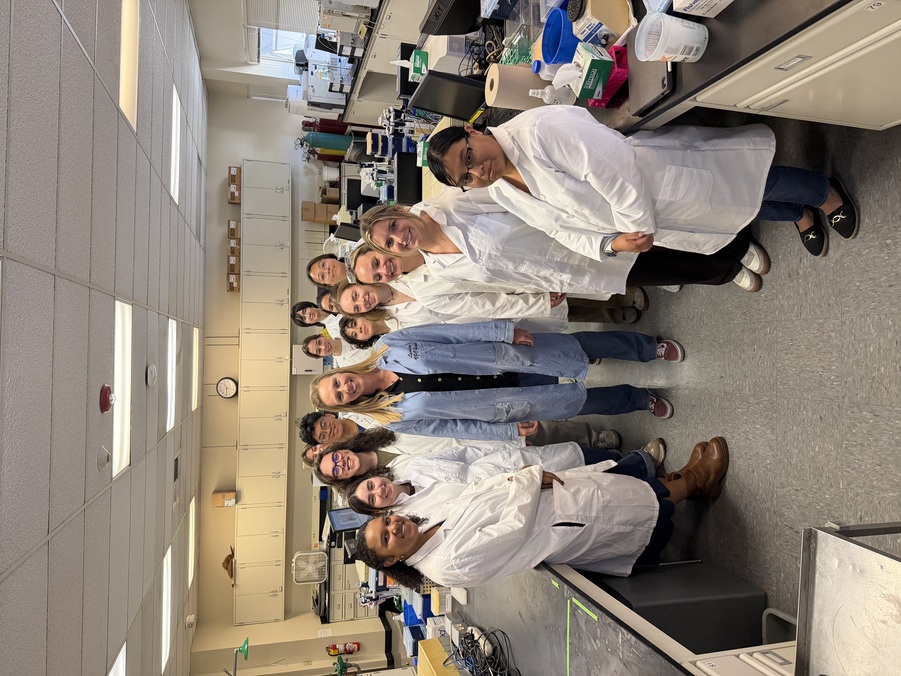 Professor and students pose in a lab.