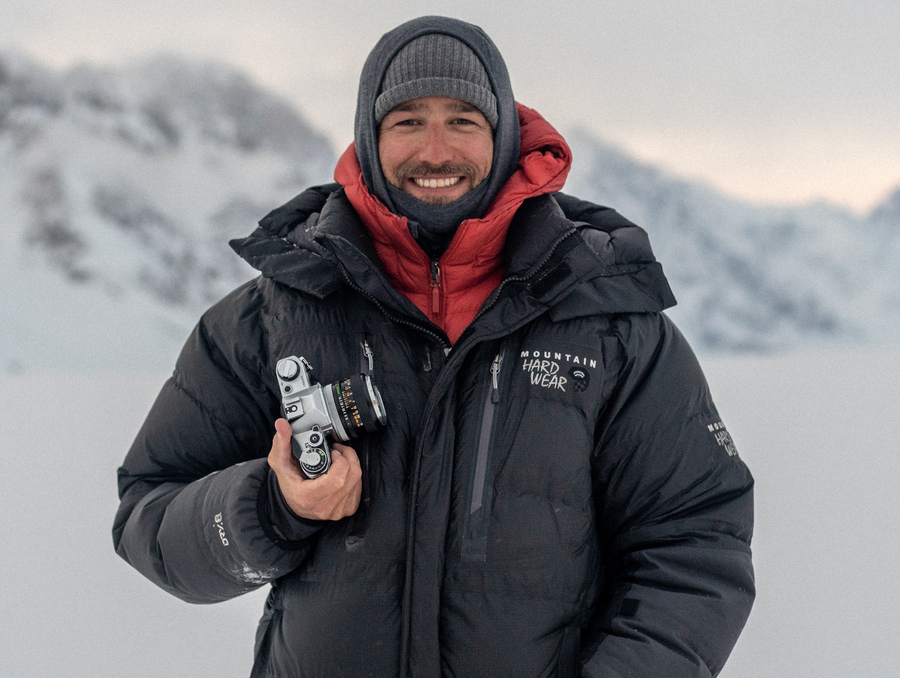 A man in the snow holding a camera.