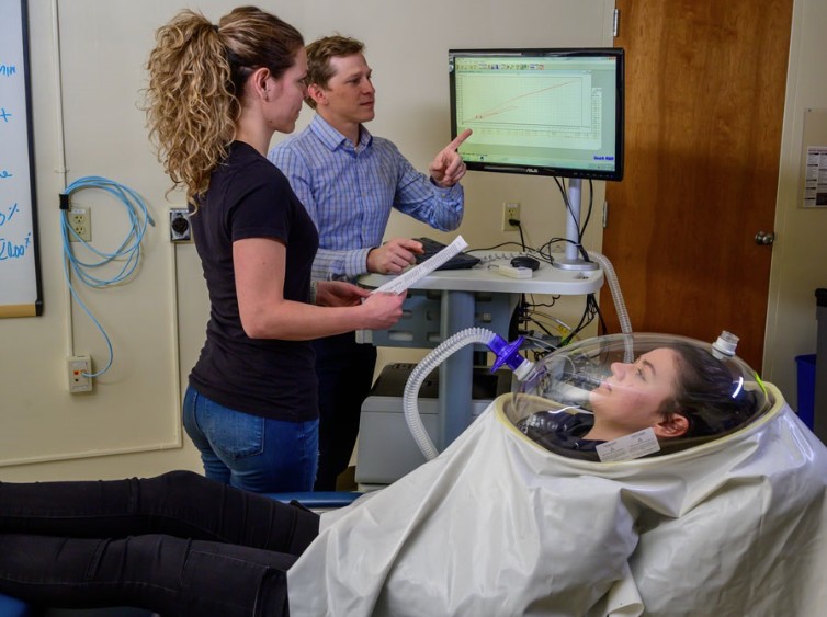 David St-Jules discusses the nutritional assessment of a model patient in a machine connected to a computer.