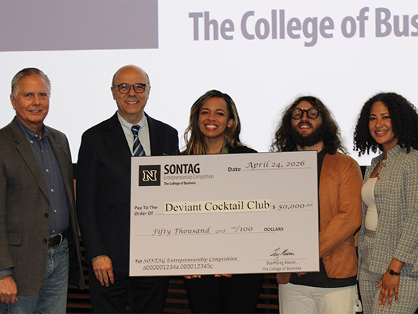 Group photo of five individuals on stage holding a large Sontag Entrepreneurship Competition check awarded to Deviant Cocktail Club.