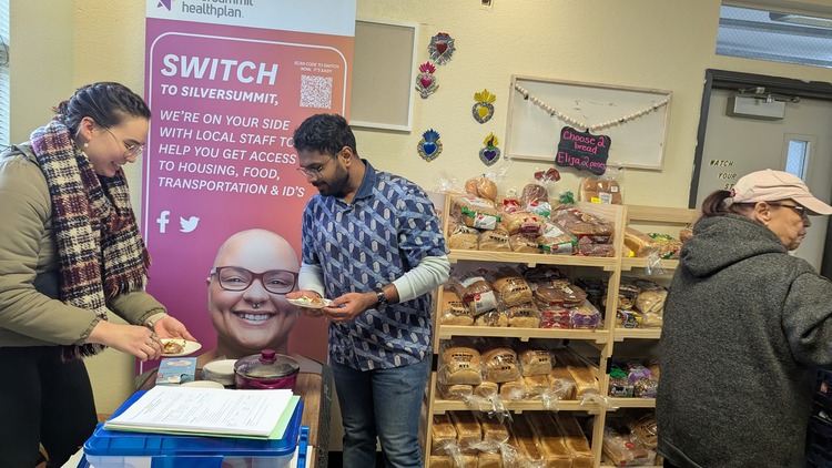 Amanda and Mohit serving cooked food in a food pantry.