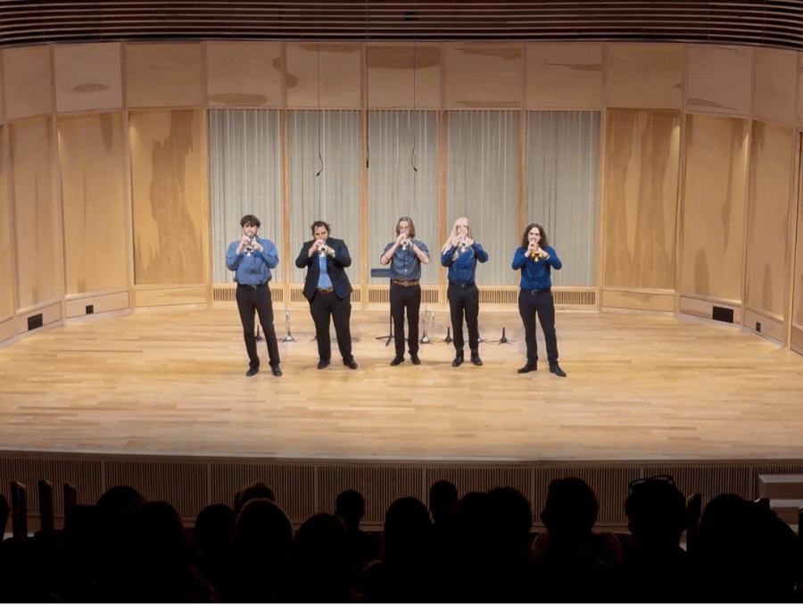 Five trumpet players on stage.