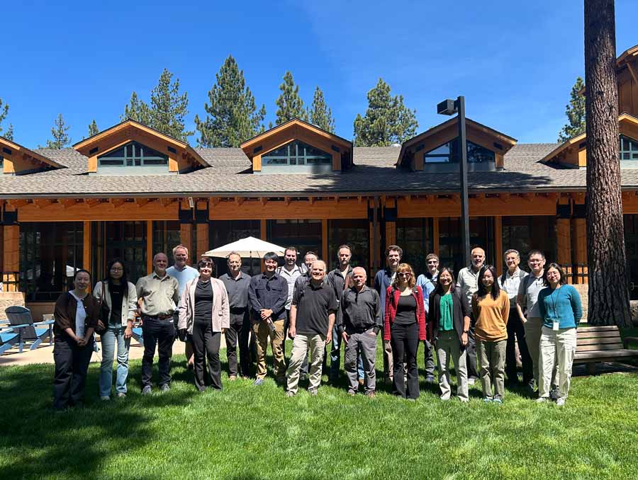 A group of people smile for a photo on the lawn at the University of Nevada, Reno at Lake Tahoe.