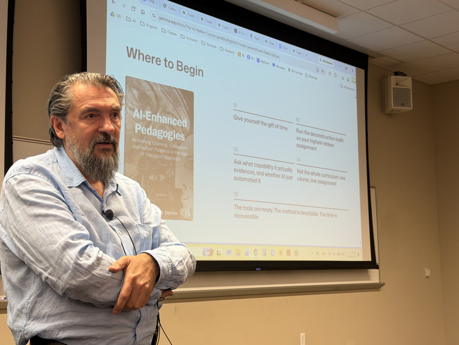 Alexander Sidorkin stands in front of a presentation screen.