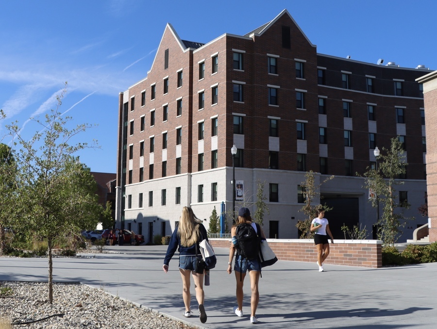 People walking across campus near the dorms.