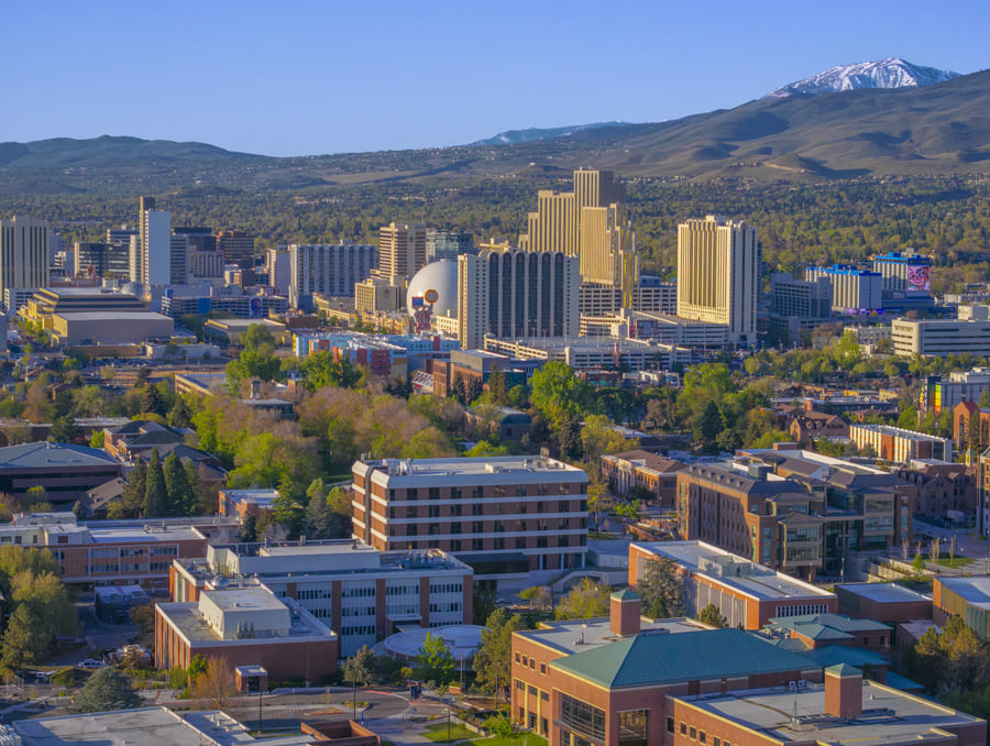 An aerial view of campus with mountains and the Reno skyline visible in the background.