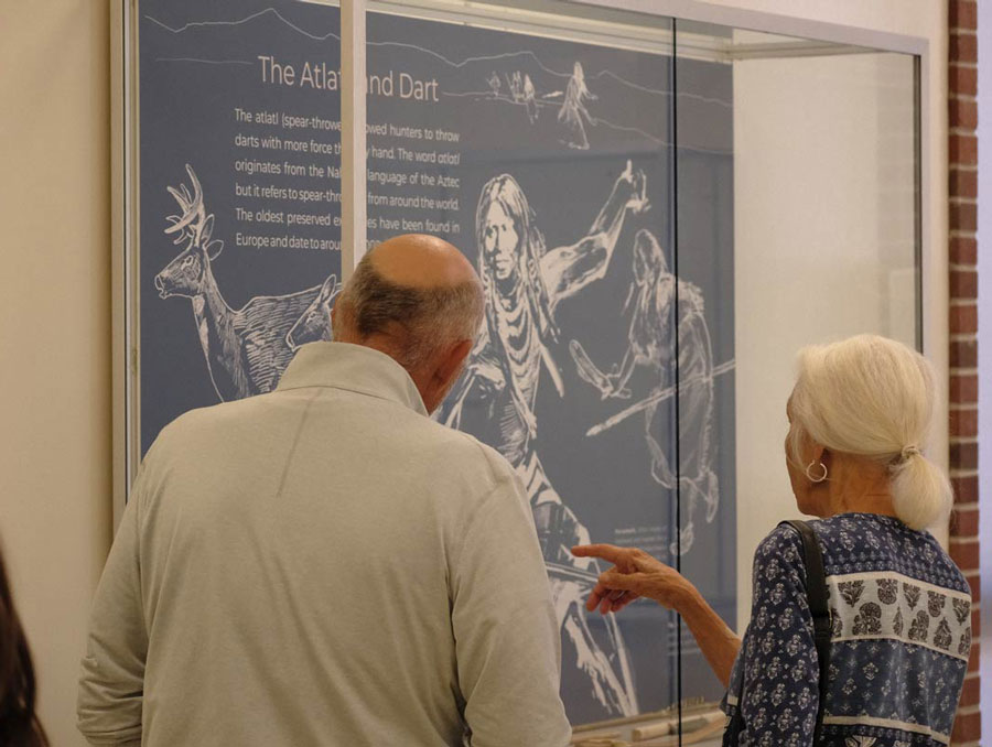 Two people look into a museum display case.