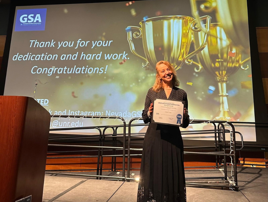 Gokce Unlu accepts an award on stage.
