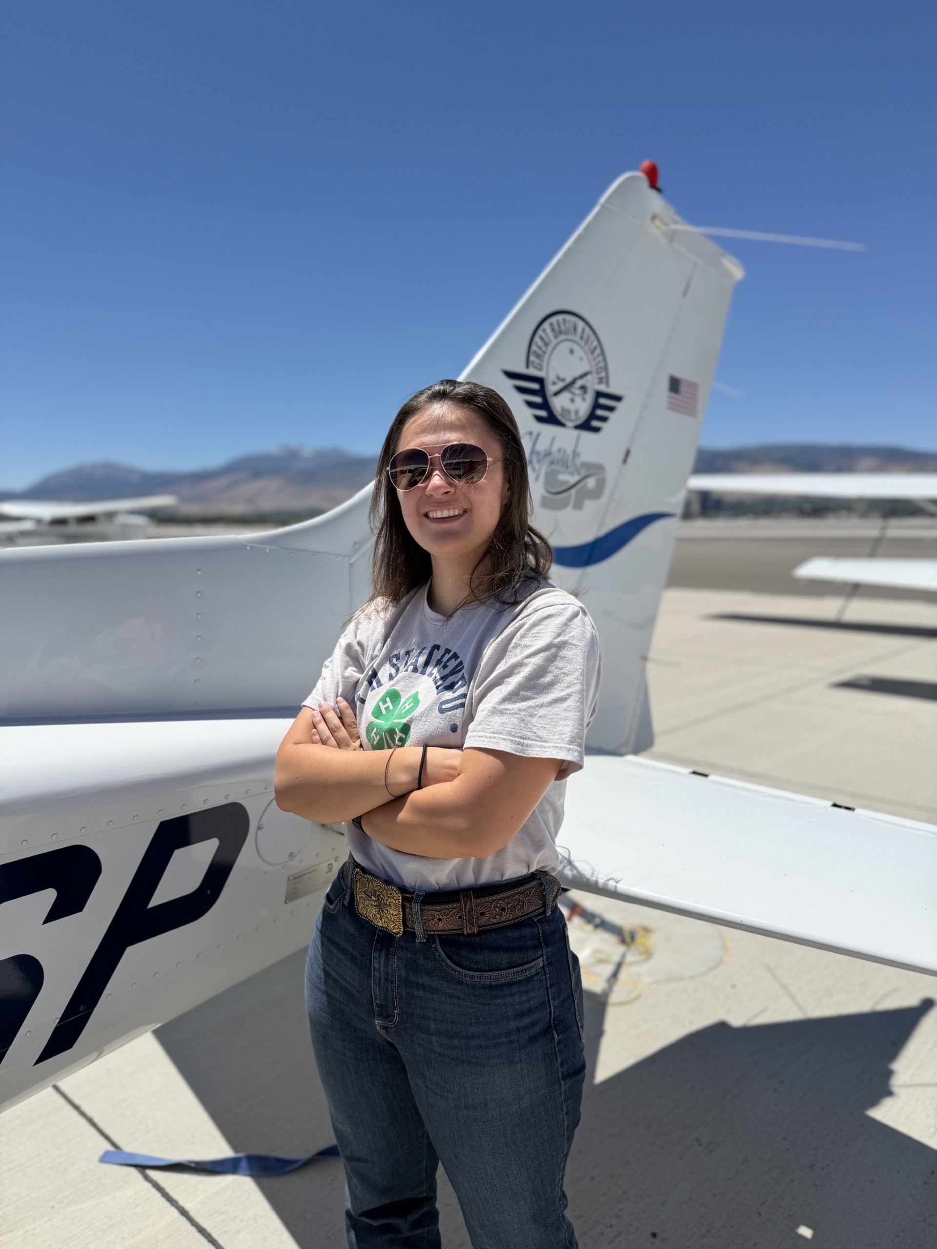 Keira Fong posing by the tail end of a plane.
