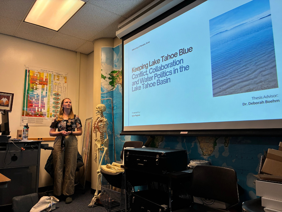Kylie Papson defending her thesis in front of a powerpoint screen.