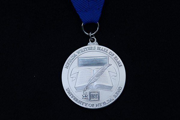 Silver medal on a blue ribbon. Text around the edge reads &ldquo;Nevada Writers Hall of Fame&rdquo; and &ldquo;University of Nevada, Reno.&rdquo;