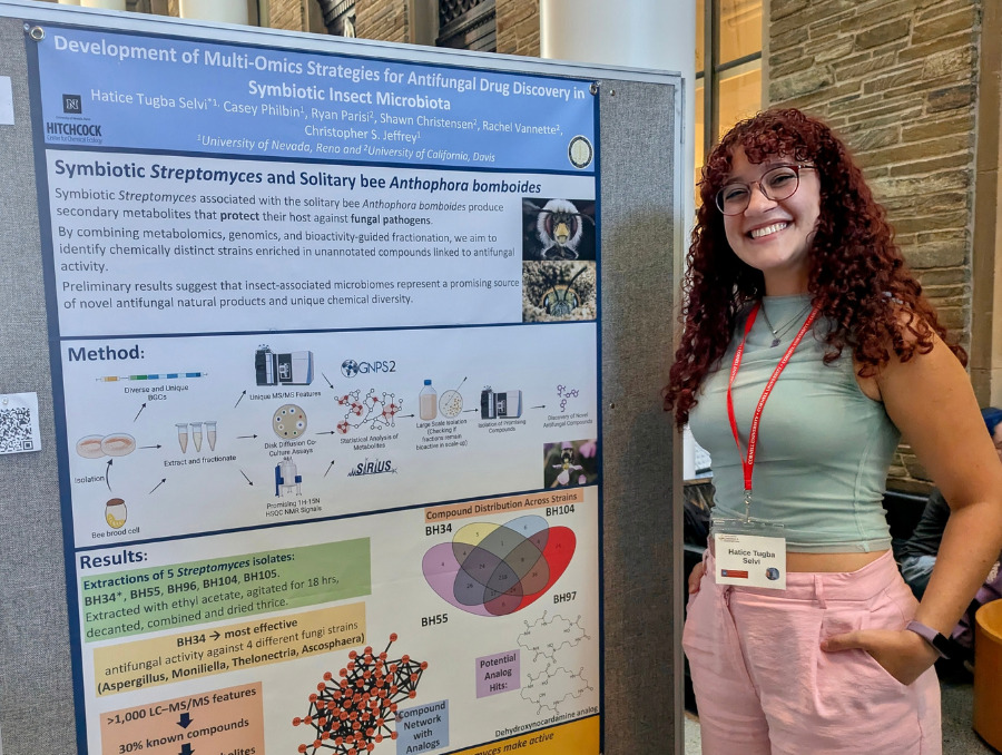 Tugba Selvi stands next to her research poster.