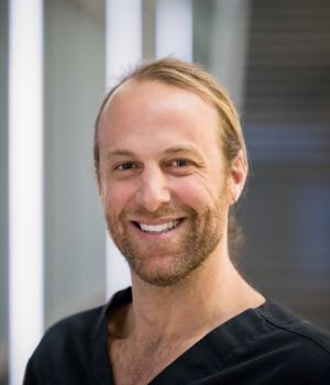 David Benaron, M.D. wearing scrubs in a headshot.