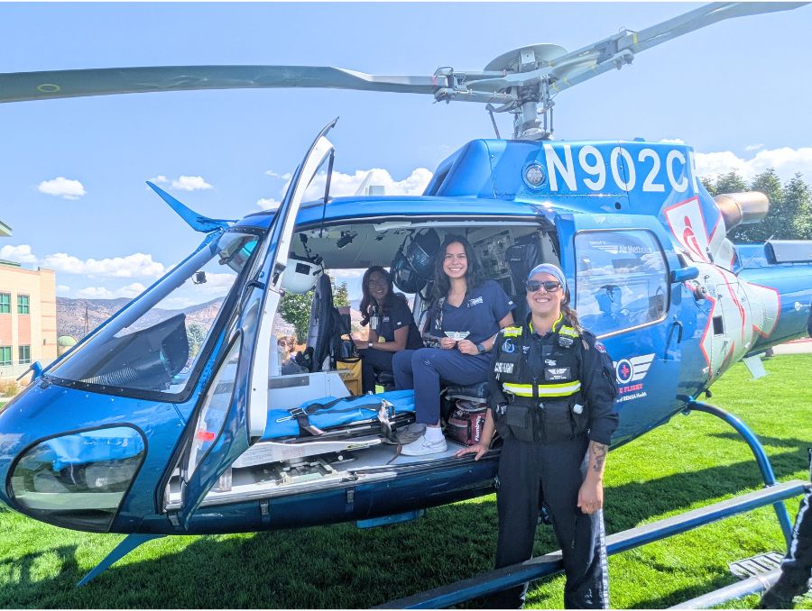 Two nursing students in a helicopter with Care Flight crew member