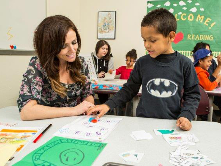 A teacher and young student working together in a classroom.